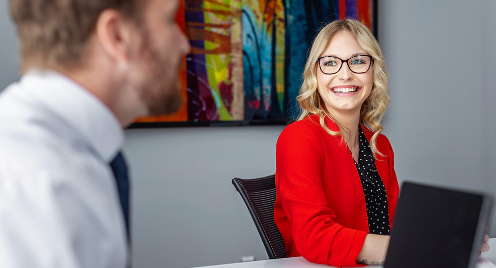 two people sitting at a conference table smiling