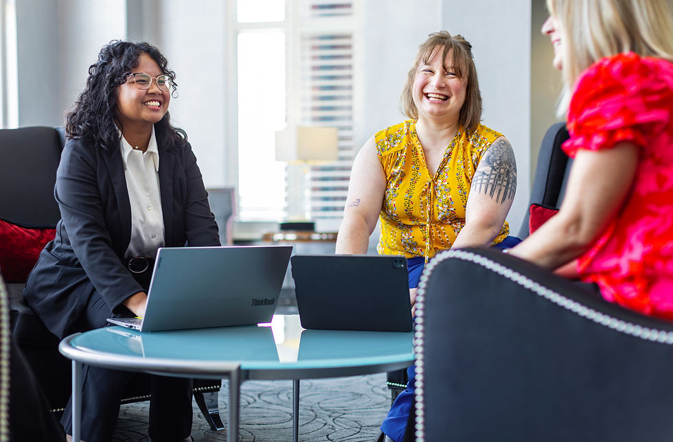 Three CFSB employees sitting around a table laughing