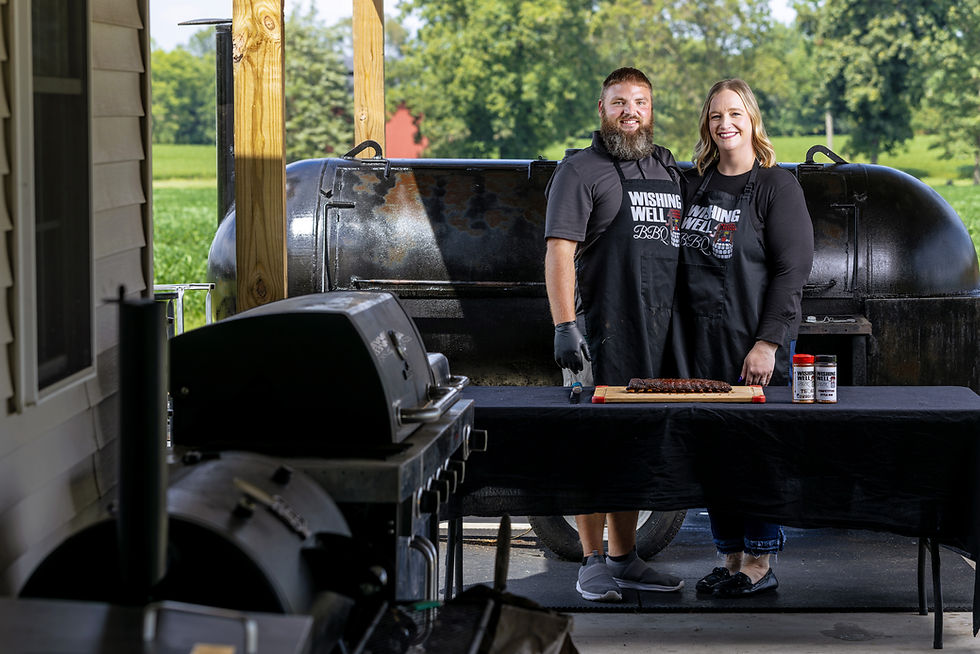 Two people standing in front of a smoker