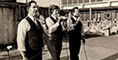 Three men singing at the first Watermelon Bust held in 1974 by Bank of Benton