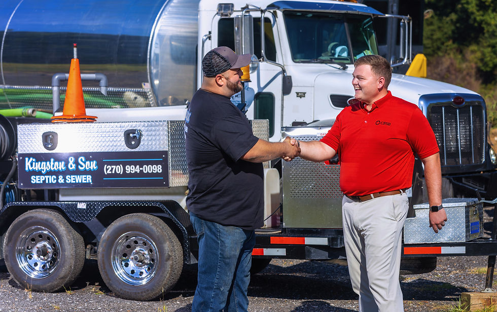 One CFSB employee shaking hands with a client in front of a large truck