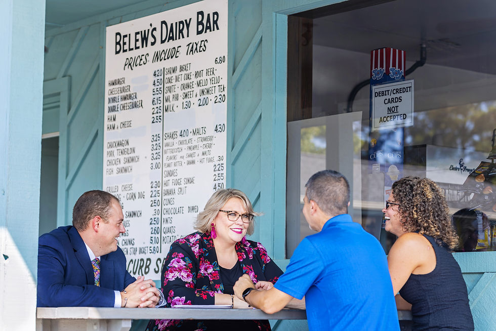 Two CFSB employees sitting at a picnic table with two customers